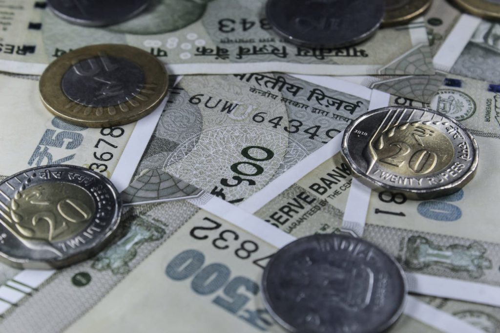 silver-coins-in-close-up-shot-14907309 Detailed view of Indian rupee banknotes and coins, showcasing currency variety.